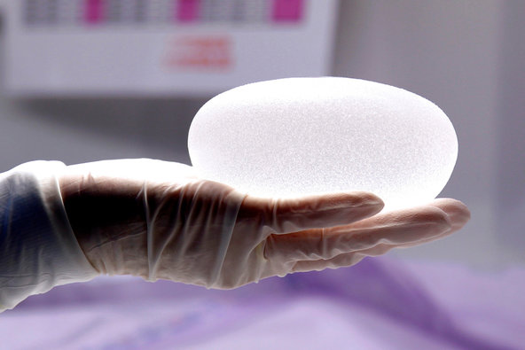 A technician helps to create a silicone gel breast implant for Sebbin Laboratories in Paris.